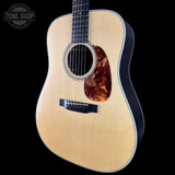 Acoustic guitar with a visible brand logo on a black background
