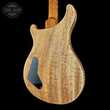 Wooden electric guitar body with 'Tone Shop' logo in the corner