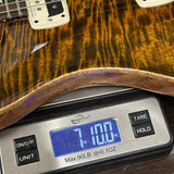 Wooden guitar on a digital scale displaying weight