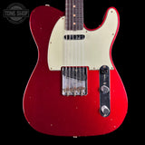 Red electric guitar with a white pickguard on a black background, featuring the Tone Shop logo.