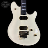 White electric guitar with gold hardware on a black background, featuring 'Tone Shop' logo.