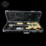 Electric guitar in a hard-shell case with 'Tone Shop' logo.