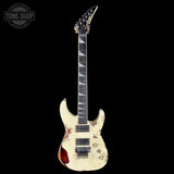 White electric guitar with a unique design on a black background, featuring the 'Tone Shop' logo.