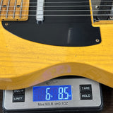 Yellow electric guitar on a digital scale displaying weight