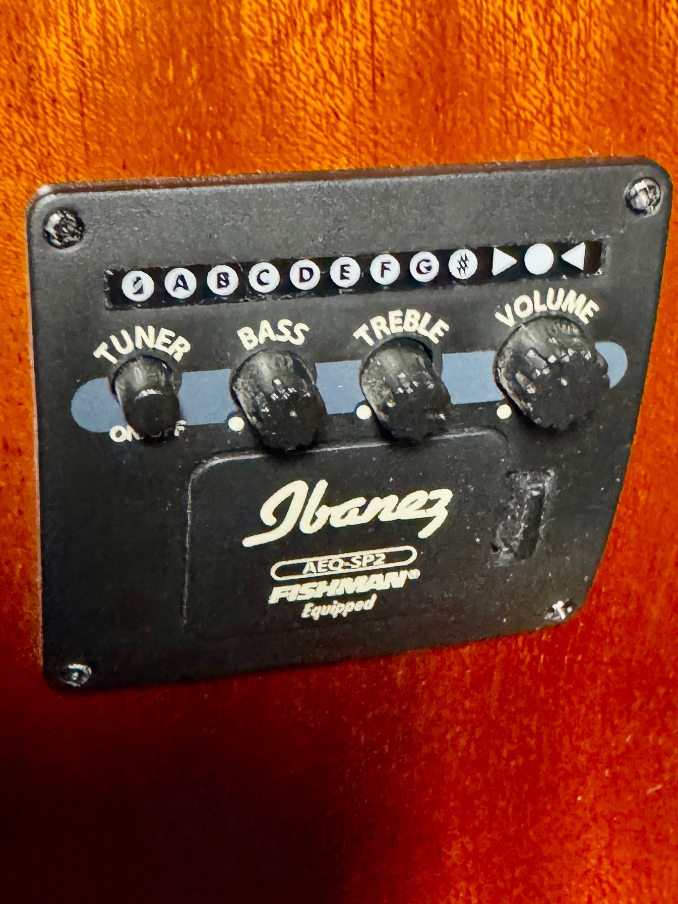 Guitar control panel with Ibanez branding on a wooden background