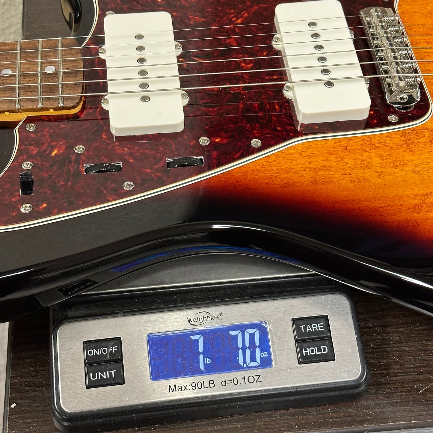 Guitar on a digital scale displaying weight