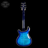 Blue electric guitar on a black background with 'Tone Shop' logo.