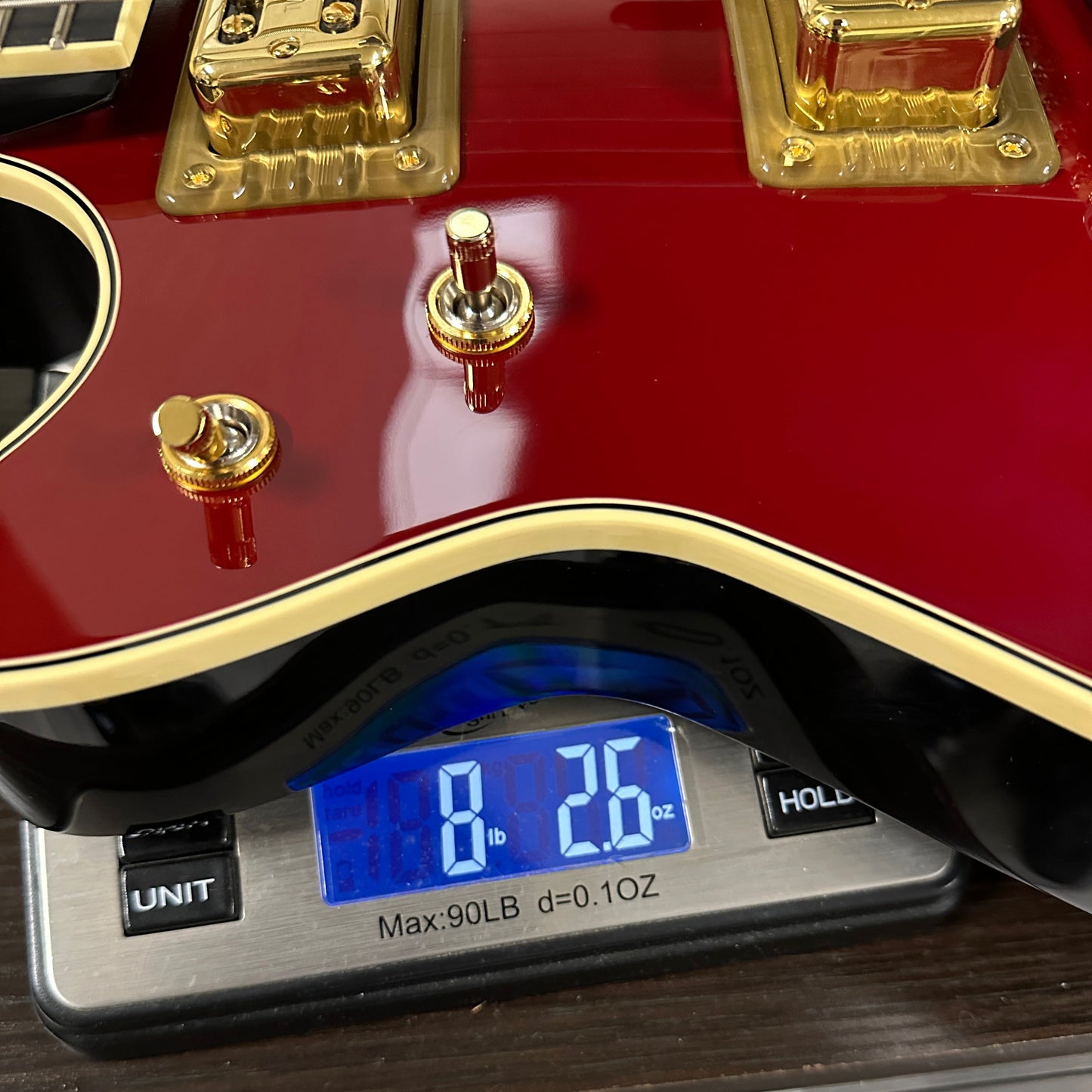 Gretsch G6131T-62 Vintage Select Duo Jet Firebird Red on scale displaying weight.