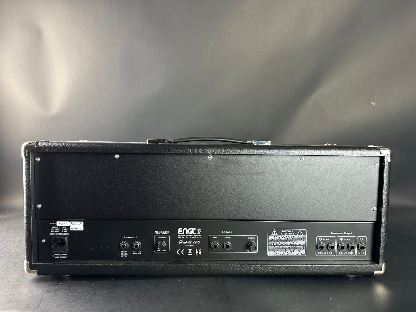 Guitar amplifier on a reflective surface with a gray background