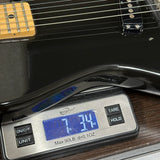 Vintage 1983 G&L SC-1 Black on scale displaying weight.