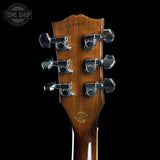 Gibson guitar headstock with tuning pegs on a black background