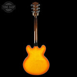 Electric guitar with a sunburst finish on a black background, featuring the Tone Shop logo.