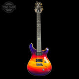 A classic electric guitar with a vibrant flame-tail gradient finish transitioning from purple and blue at the top, through orange and yellow, to red at the lower bout. The neck is dark wood with gold hardware and a star inlay, photographed against a solid black background.
