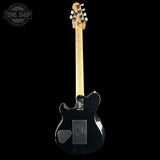 A black electric guitar with a natural maple neck, shown from the back against a solid black background. A Tone Shop watermark is visible in the top-left corner.