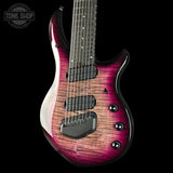 A close-up of an electric guitar body showing a vibrant cherry flame finish that transitions from deep magenta to a warm brown woodgrain. The guitar features black hardware, pickups, and control knobs, set against a solid black background with a Tone Shop watermark in the upper left corner.