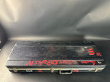Black guitar case with red text on a gray surface