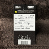 A product authentication card for aPRS Guitar Strings, featuring a black header with white text and a white writing area with handwritten details, placed on a dark brown furry surface.