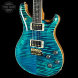 A turquoise and teal electric guitar with a flamed maple top, gold hardware, and a dark fretboard, shown against a black background with a Tone Shop watermark in the top-left corner.