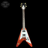 A Fender electric guitar with a red-orange sunburst finish, white pickguard, and gold hardware, shown against a solid black background with a Tone Shop watermark in the top-left corner.