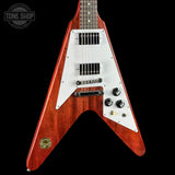 A classic electric guitar with a reddish-brown wood body, white pickguard, and black hardware, shown against a solid black background. A circular 'TONE SHOP' watermark is visible in the top-left corner.