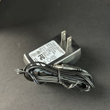 Power adapter with a coiled cable on a dark surface