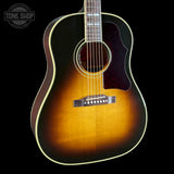 A classic acoustic guitar with a sunburst finish, featuring a dark brown outer edge fading to a warm golden-orange center, set against a solid black background.