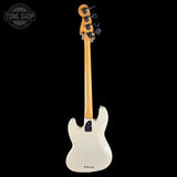A white electric bass guitar shown from the back, featuring a natural maple neck, black tuners, and a black control plate, photographed against a solid black background with a Tone Shop watermark in the top-left corner.