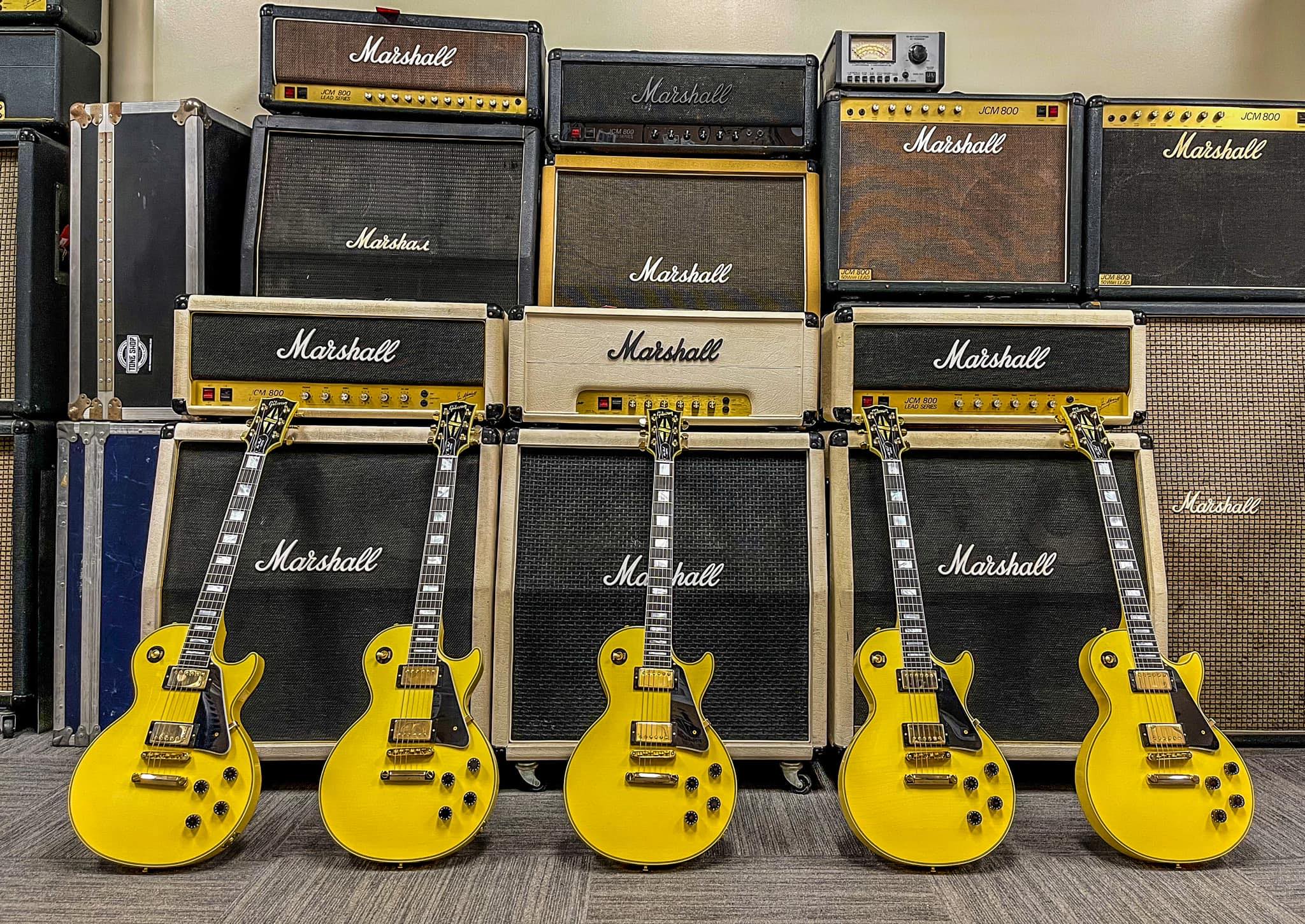 Marshall amplifiers with multiple Gibson Les Paul guitars. 