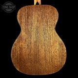 Close-up of a wooden acoustic guitar back with 'Tone Shop' logo.