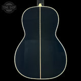 Back view of a black acoustic guitar with 'Tone Shop' logo.
