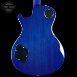Blue electric guitar body with a 'Tone Shop' logo in the corner.