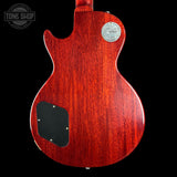Back view of a red electric guitar with a visible brand logo on a black background.