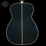 Back view of a black acoustic guitar with a visible brand logo in the corner.