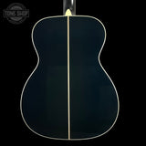 Back view of a black acoustic guitar with a visible brand logo in the corner.