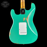 Teal electric guitar with a worn finish on a black background, featuring 'Tone Shop' branding.