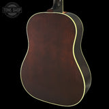 Back view of a wooden acoustic guitar with a dark brown finish on a black background.