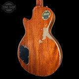 Back view of a Gibson electric guitar with a visible brand logo on a black background.