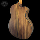 Wooden acoustic guitar body with 'Tone Shop' logo in the corner