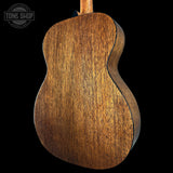 Close-up of a wooden acoustic guitar body with 'Tone Shop' logo.