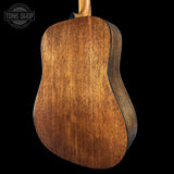 Close-up of a wooden acoustic guitar back with 'Tone Shop' logo.
