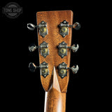 Close-up of a guitar headstock with tuning pegs on a black background, featuring the Tone Shop logo.