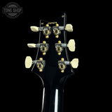 Close-up of a guitar's tuning pegs with a black background and 'Tone Shop' logo.