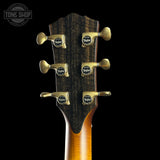 Guitar headstock with tuning pegs on a black background, featuring the Taylor logo.