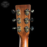 Close-up of a guitar headstock with tuning pegs on a black background, featuring the Tone Shop logo.