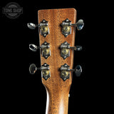 Close-up of a guitar headstock with tuning pegs on a black background, featuring the Tone Shop logo.