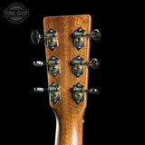 Close-up of a guitar headstock with tuning pegs on a black background, featuring the Tone Shop logo.