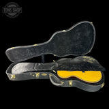 Guitar case with yellow interior on a black background, featuring the Martin logo.