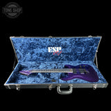 Purple electric guitar in an open blue case with ESP brand logo.