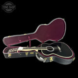 Acoustic guitar in a case with 'Tone Shop' logo in the corner