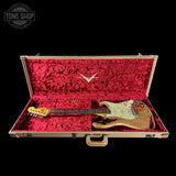 Electric guitar in a red-lined case with a visible brand logo on a black background.